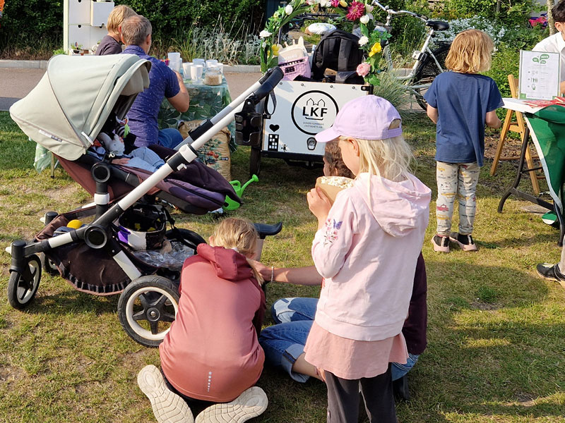 Bild på en grupp av barn och vuxna och en barnvagn som hänger utomhus på en LKF-aktivitetsdag