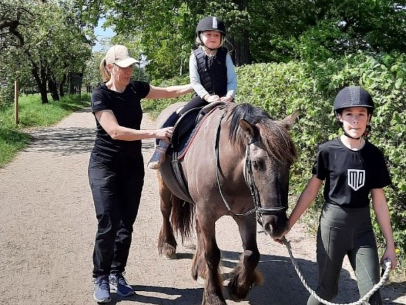 Bild på ett barn som rider på en ponny
