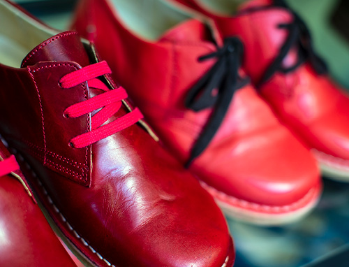 Närbild på röda skor med röda och svarta skosnören.